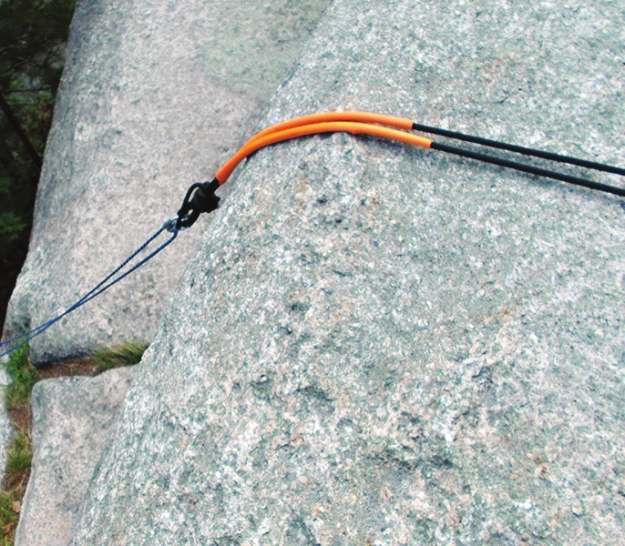An anchor extension of orange webbing running over a slab edge to a new master point