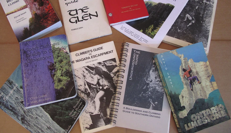 Une sélection de topoguides d’escalade canadiens étalés sur une table