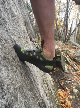 Un chausson d’escalade en adhérence, à plat contre une surface rocheuse peu inclinée